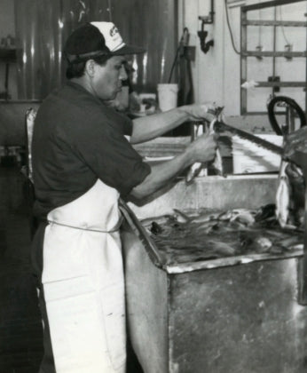 vintage photo of man hanging fish to make smoked fish