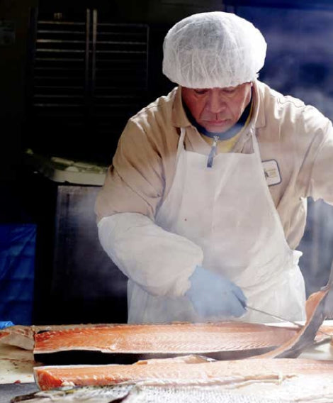man cutting salmon for smoked salmon